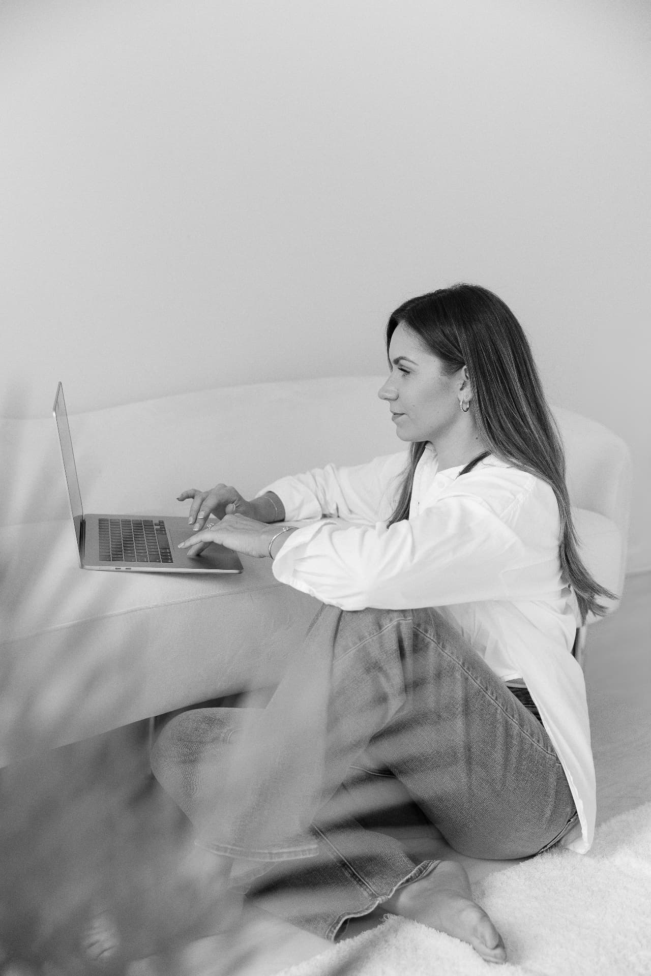 Black and white portrait of Alyssa working at her laptop